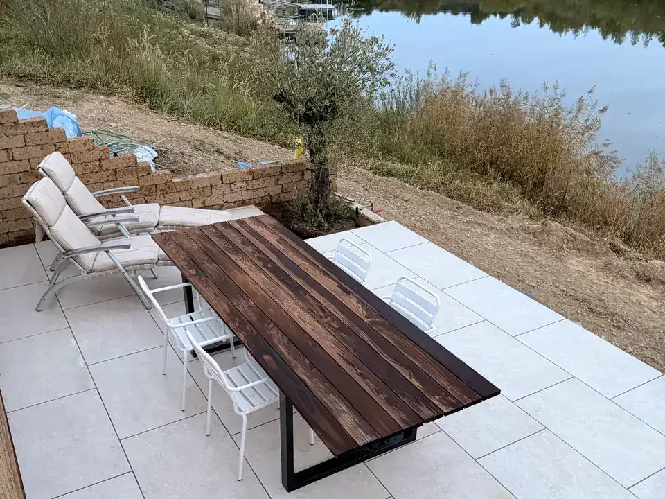 Fertige Terrasse aus heller Feinsteinzeug-Keramik am See in Mietingen-Baltringen bei Biberach, mit Holztisch, Stühlen und Liegen