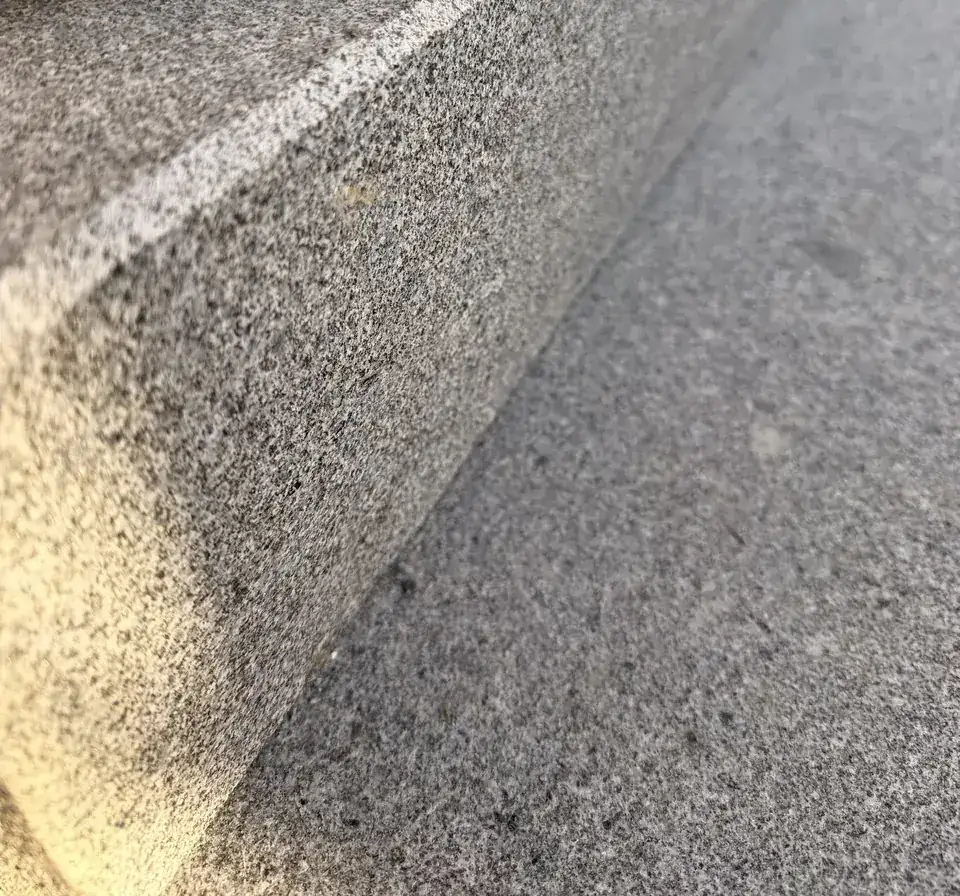 Vorderkante einer Granitstufe mit heller, fein gefaster Kante