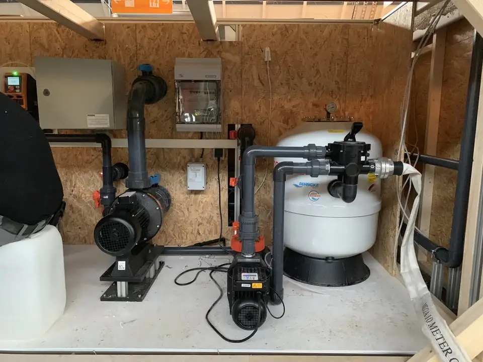 Pooltechnik mit Pumpen, Sandfilter und Steuerung unter dem Holzdeck