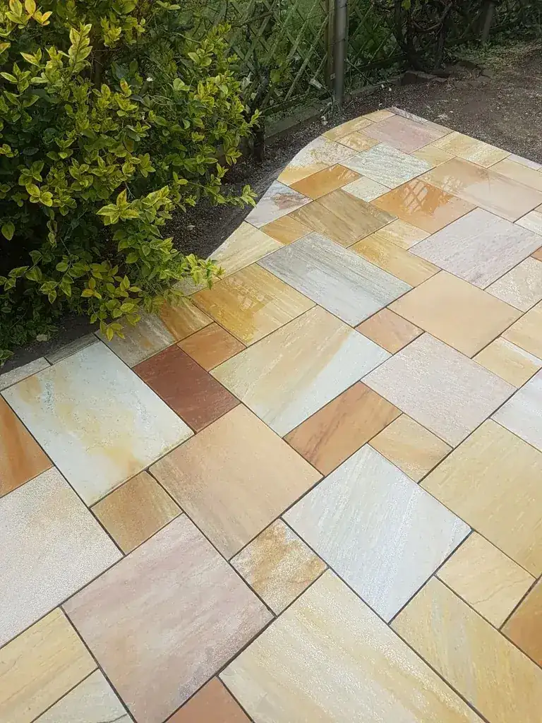 Terrasse aus mehrfarbigem Sandstein im Wildverband mit geschwungenem Rand am Beet, Kirchheim unter Teck
