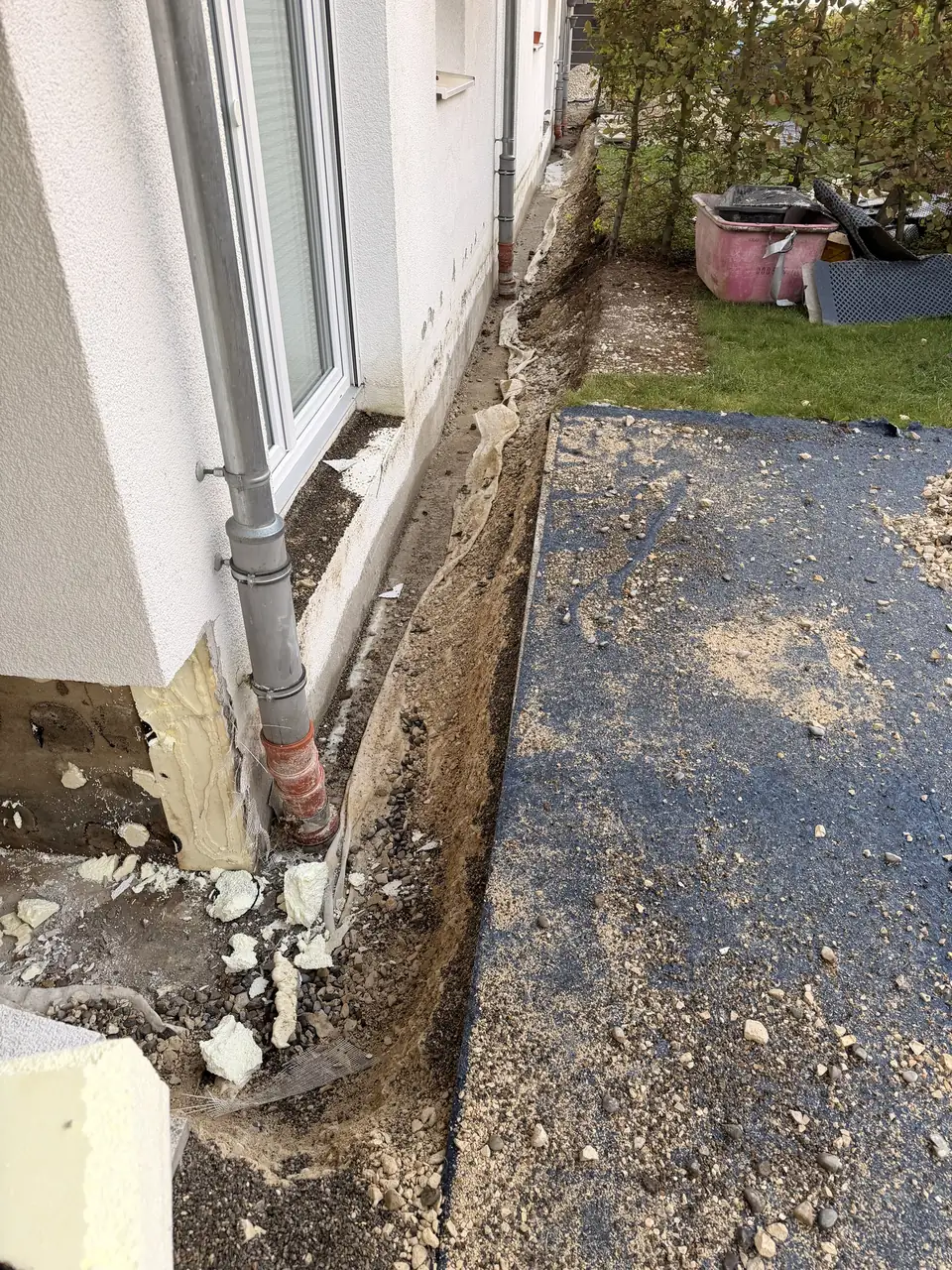 Entlang der Hauswand freigelegter Graben bis auf die Tiefgaragendecke, daneben die abgedeckte Fläche
