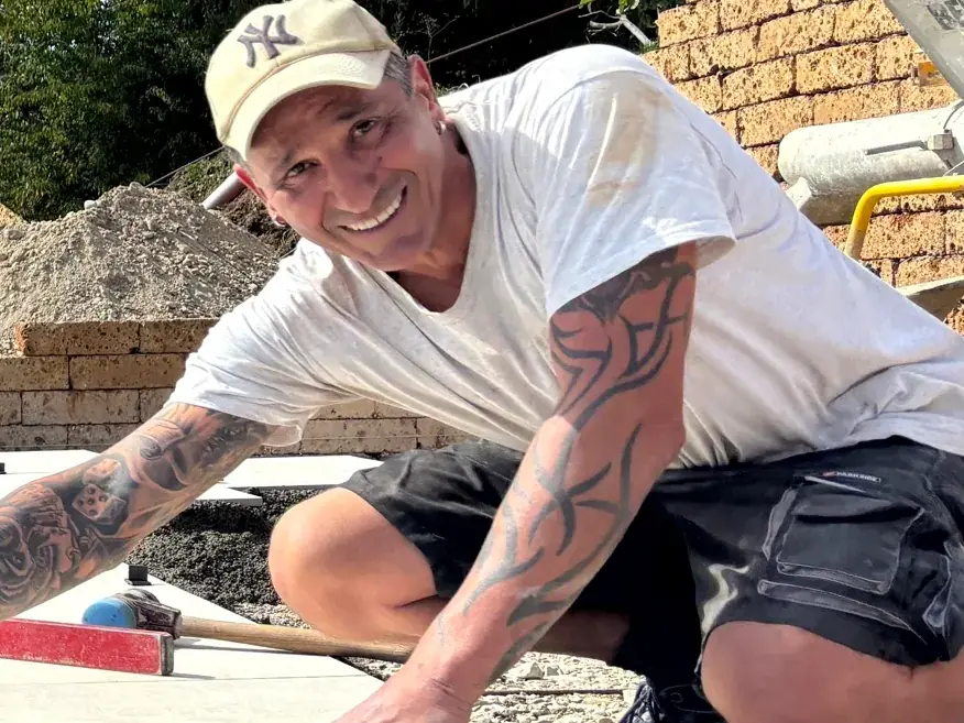 Lachender Mitarbeiter beim Verlegen der Keramikplatten