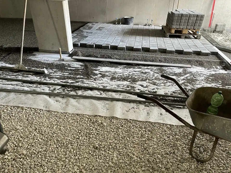 Pflaster wird in einer Tiefgarage auf Vlies, Drainschicht und Splittbett verlegt